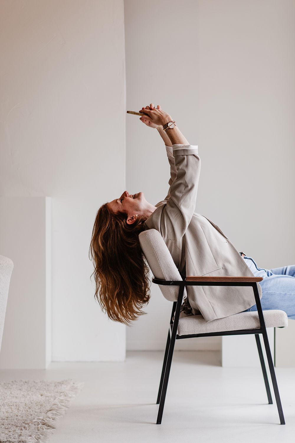 Zakelijke fotoshoot met een creatieve vrouwelijke ondernemer die spontaan en vrolijk op de foto staat.