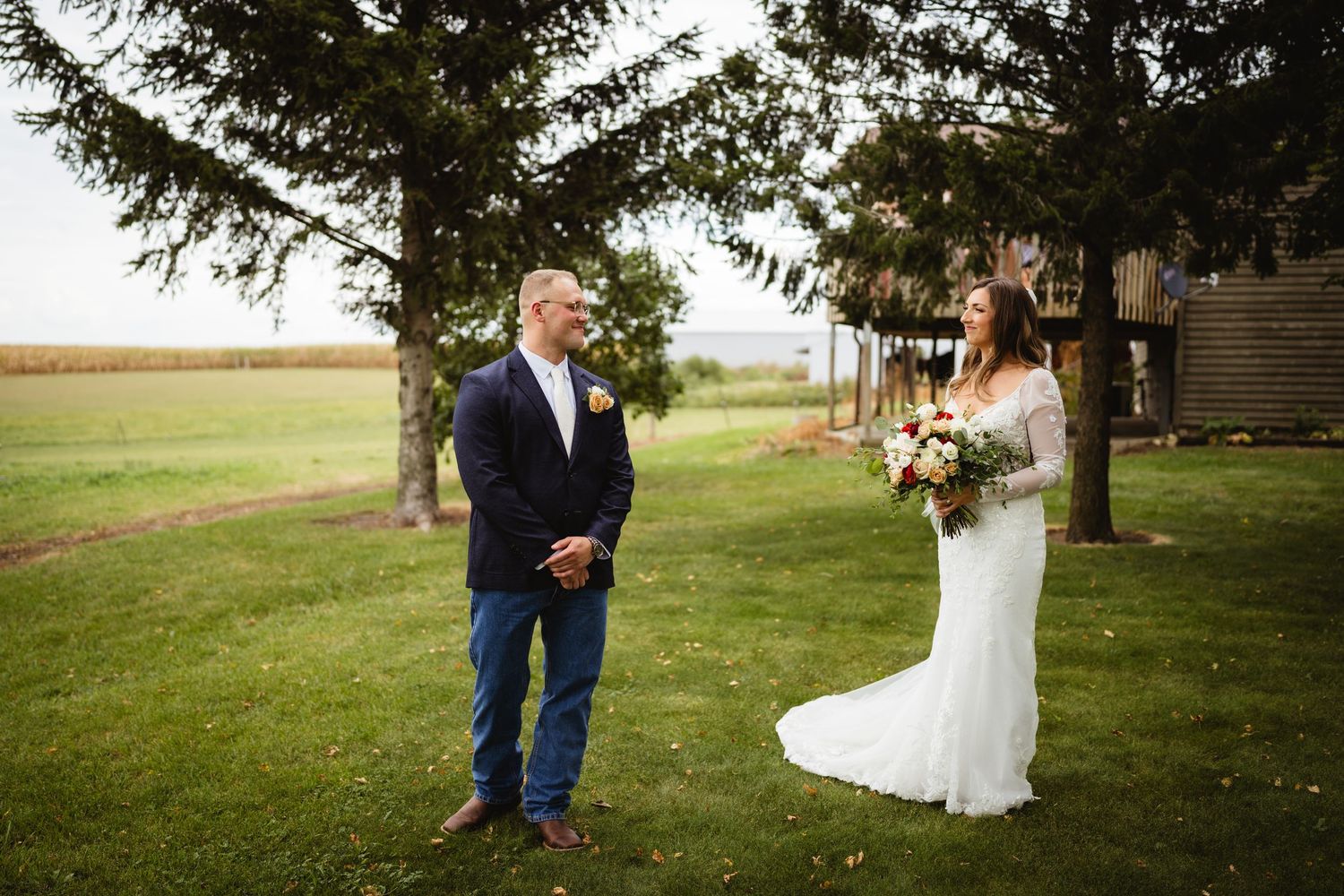 Bride and groom share an intimate moment in an outdoor garden setting surrounded by greenery and natural light.
