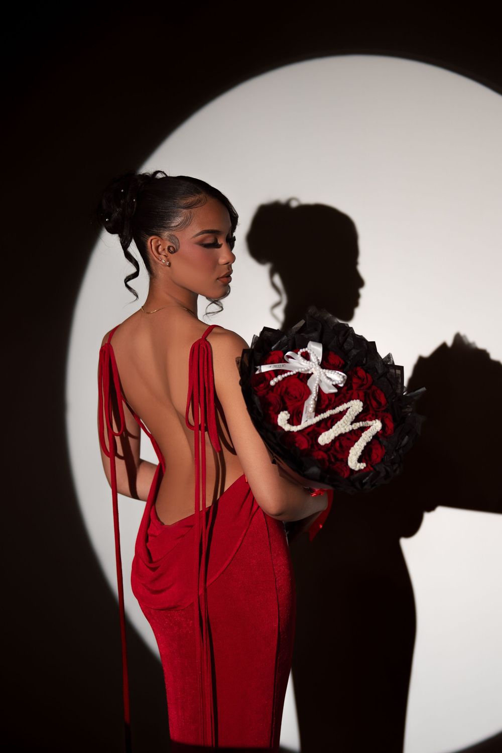 Dramatic silhouette series showing a person in a red dress against a dark background with a bright circular spotlight.