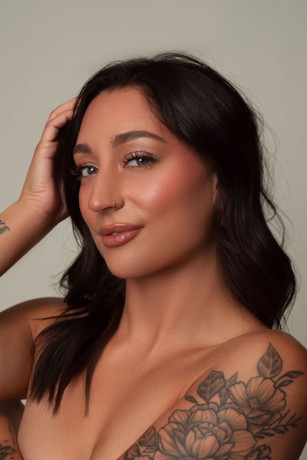 A series of glamour portraits showing dark hair, tattoos and makeup in various artistic poses against a neutral background.