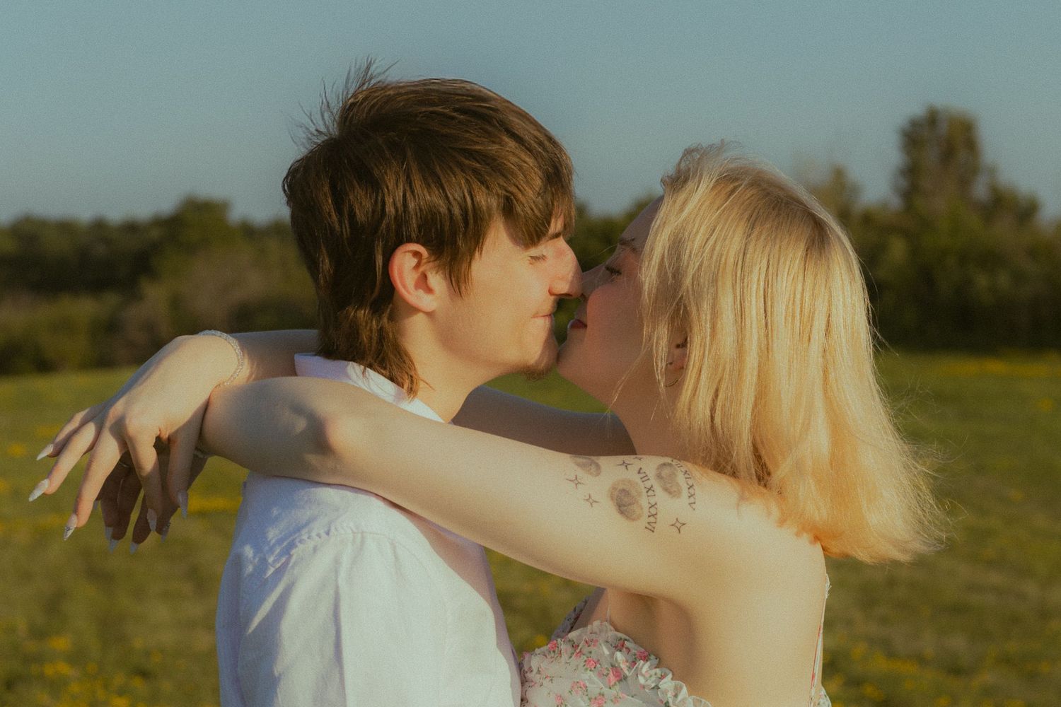 Intimate couple's portrait session during golden hour in natural setting.