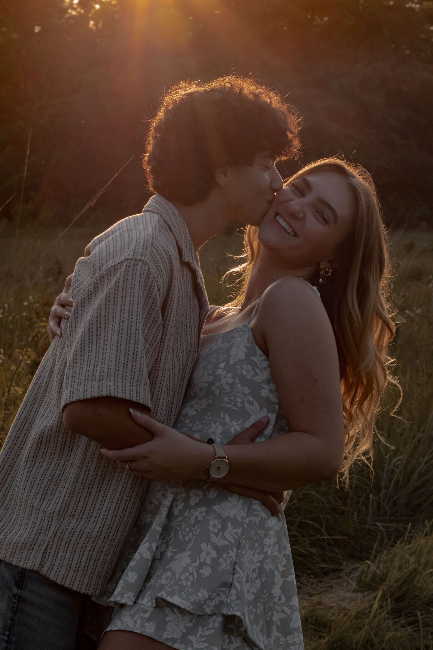 Intimate couple's portrait session during golden hour in natural setting.