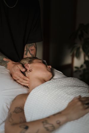 Close-up view of a person lying on bedsheets during a relaxing massage treatment.
