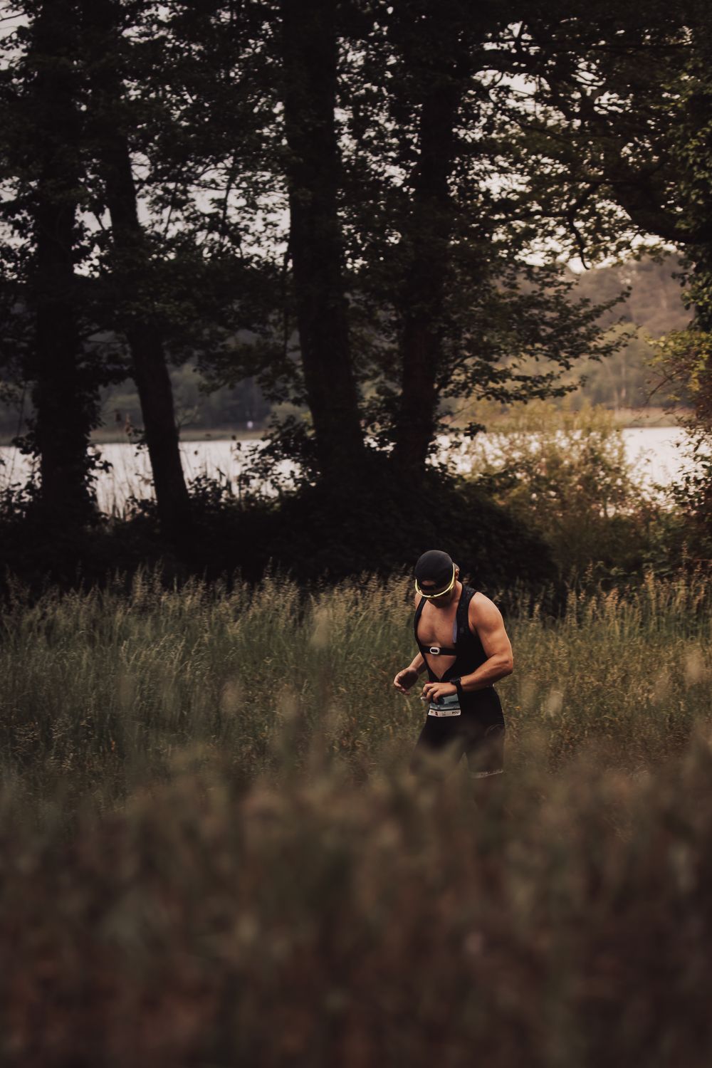 Une série de photos montrant quelqu'un en tenue d'entraînement faisant de l'exercice dans une zone boisée près d'un lac au crépuscule.
