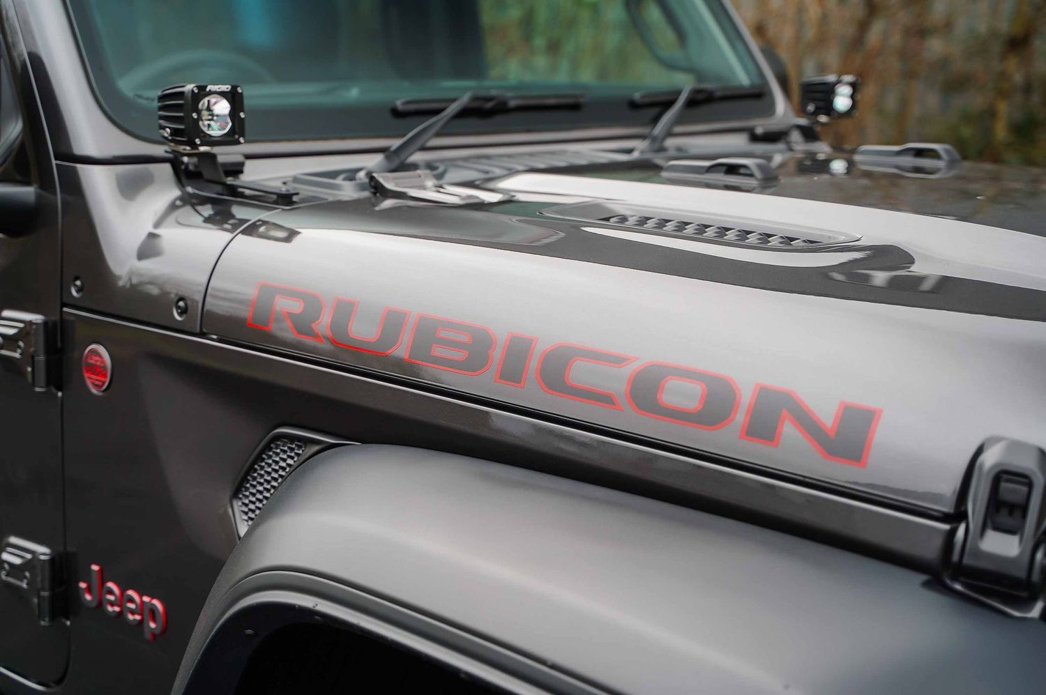 Close-up of Jeep hood with Rubicon decal and custom modifications.