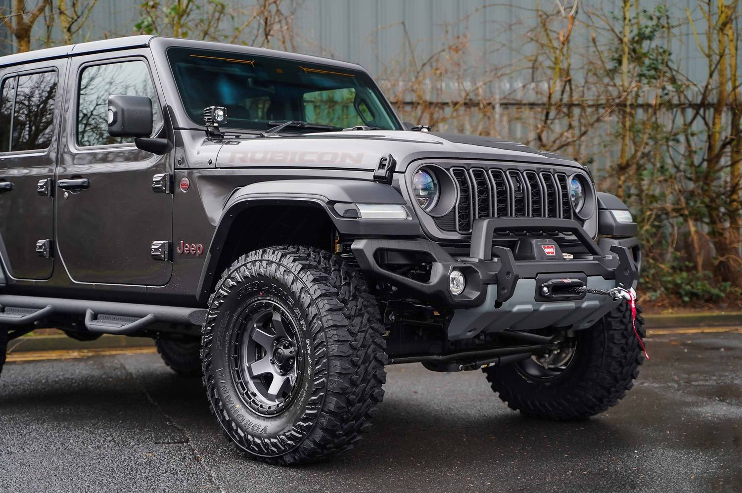 Custom Jeep Wrangler with aggressive off-road tires and lifted suspension.