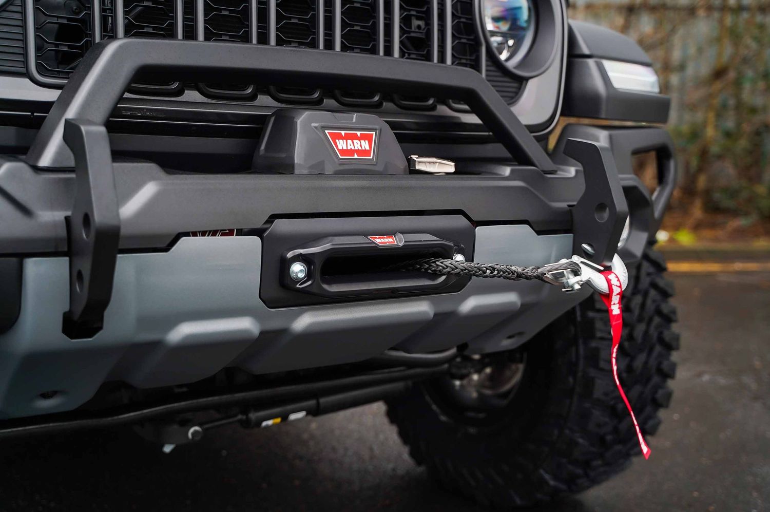 Modified Jeep Wrangler front bumper with winch and LED lighting.