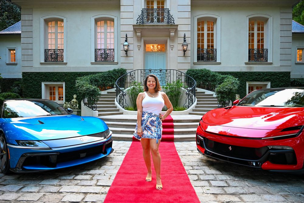 A series of luxury sports cars including Ferrari and Lamborghini models parked in front of an elegant mansion driveway.