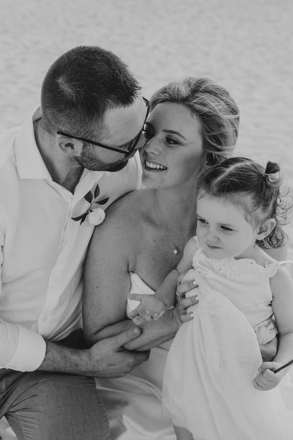 Four black and white candid photos show an intimate moment between a couple against a light background.