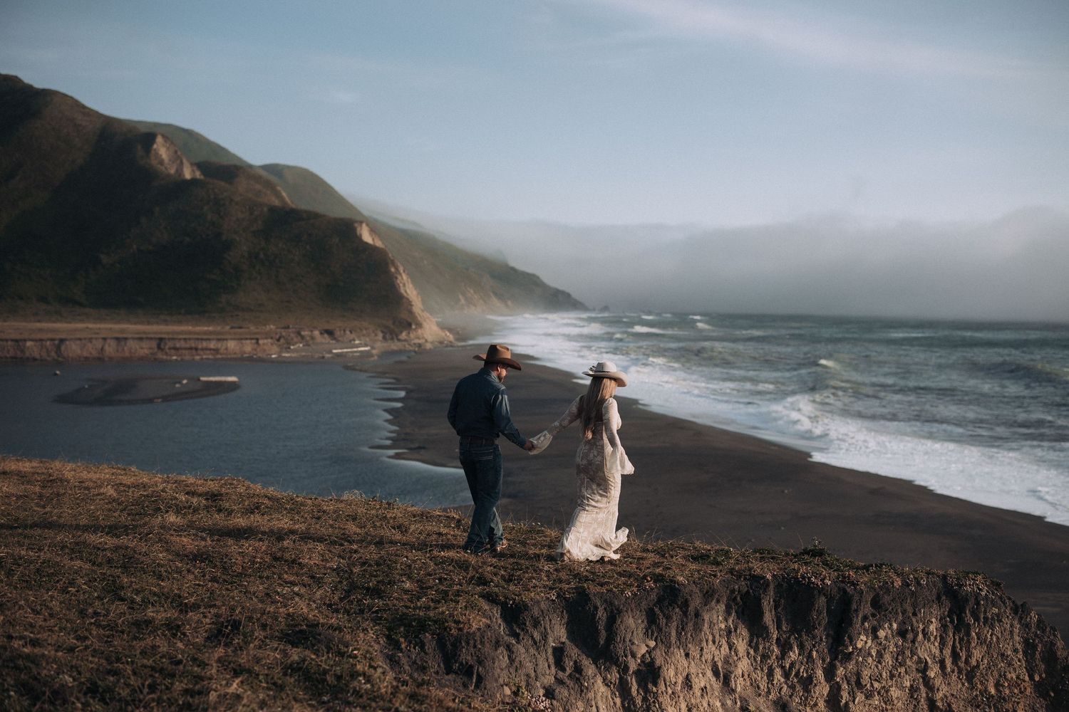 western couple walking and overlooking Northern California ocean cliff