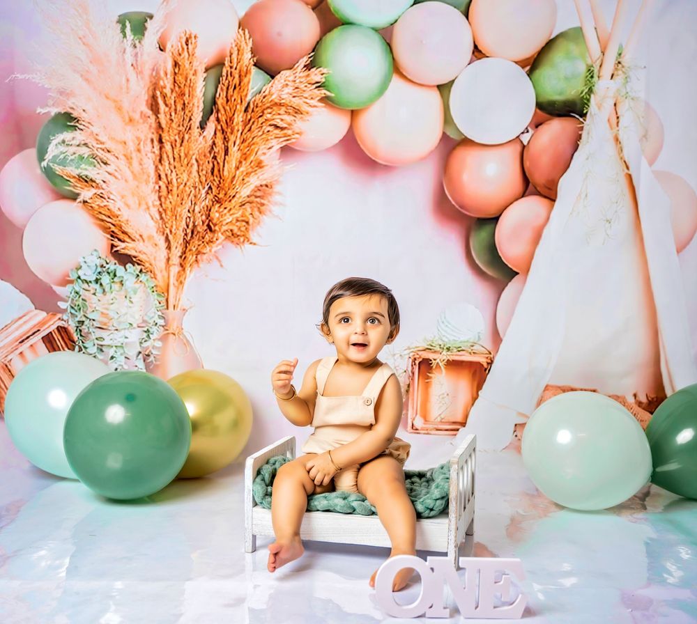 A festive pastel balloon and pampas grass party setup with mint, coral, and blush tones creates a dreamy backdrop.