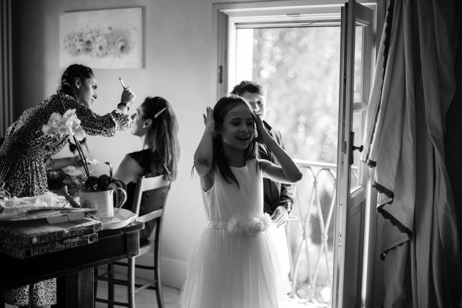 Black and white photos showing wedding day preparation with dresses and natural light.