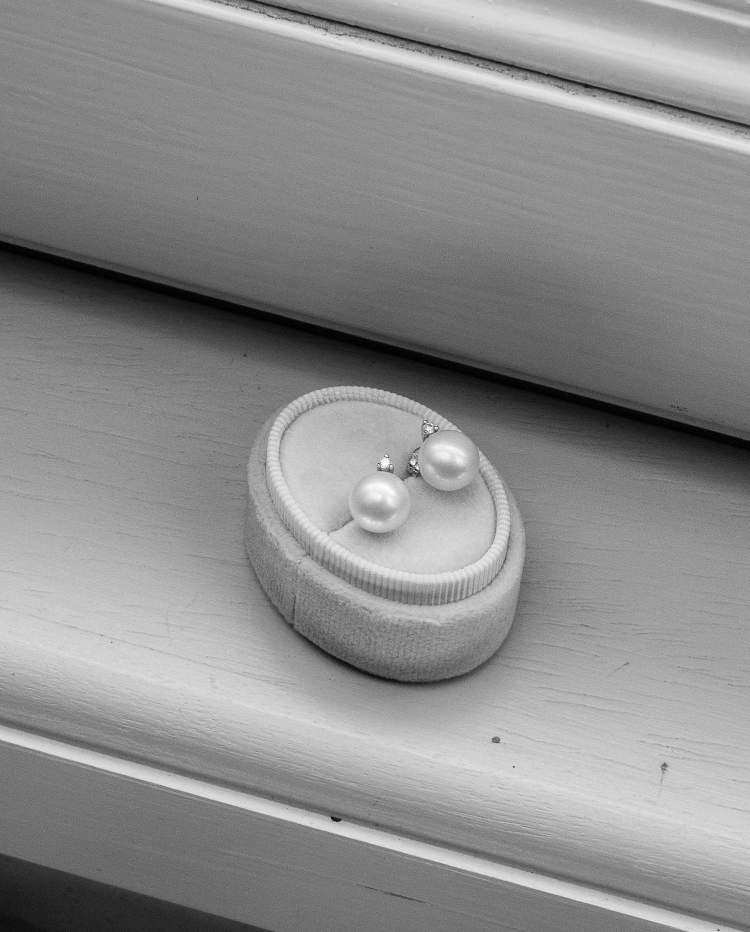 Close-up sequence of pearl and ring details on a white surface.