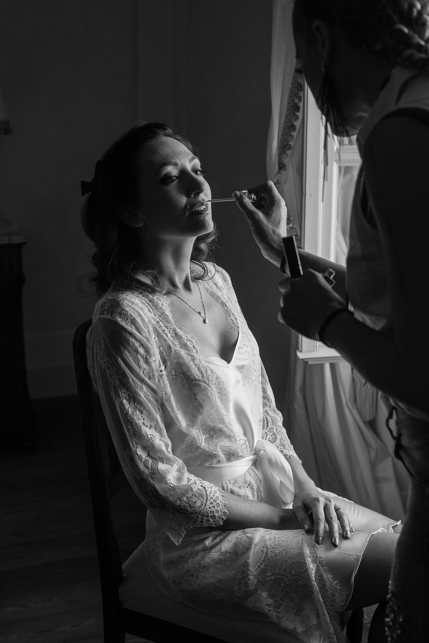 Artistic black and white shots of a bride getting ready in a lace robe.