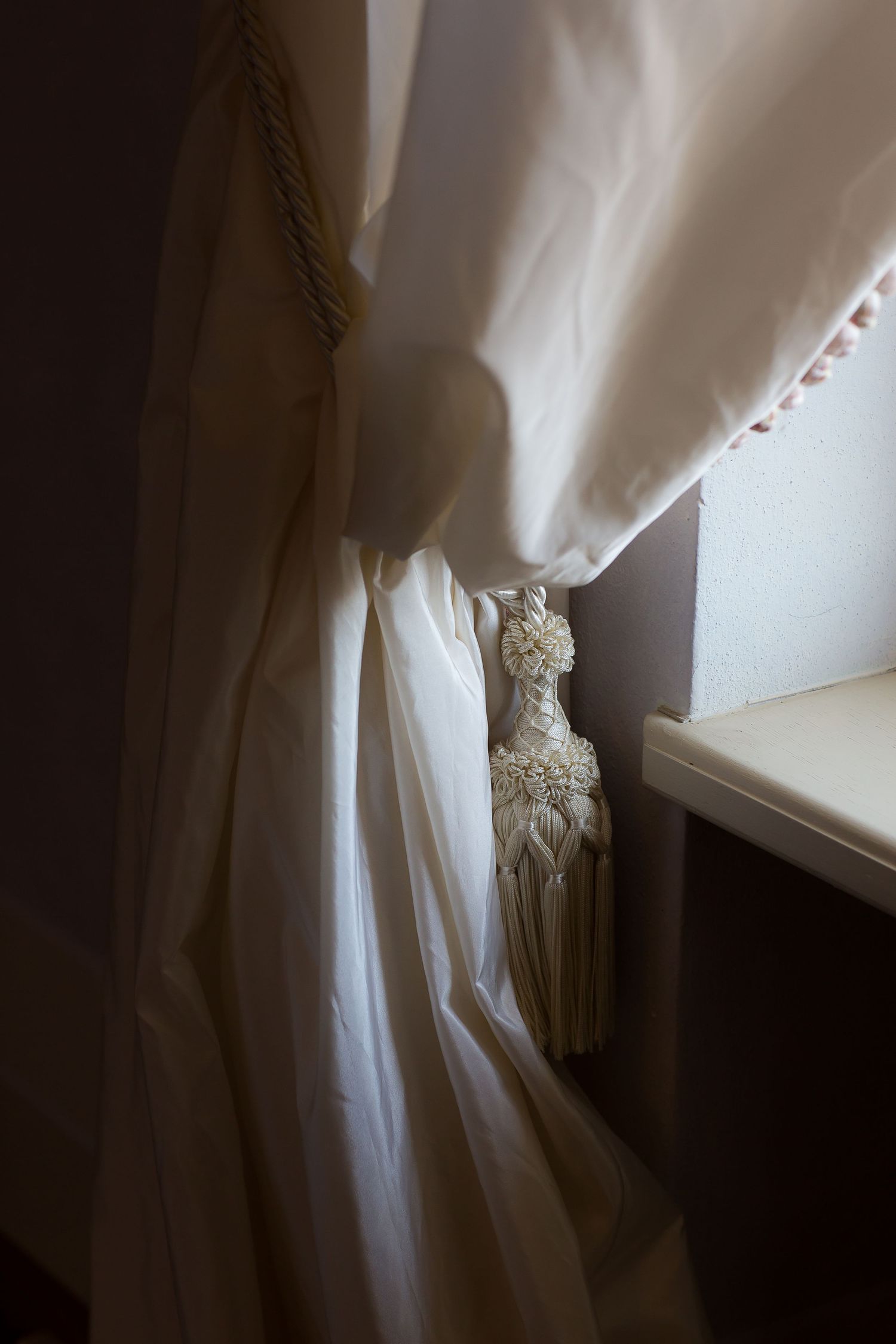Ethereal white curtains billow softly near a window, creating a dreamy atmospheric scene.