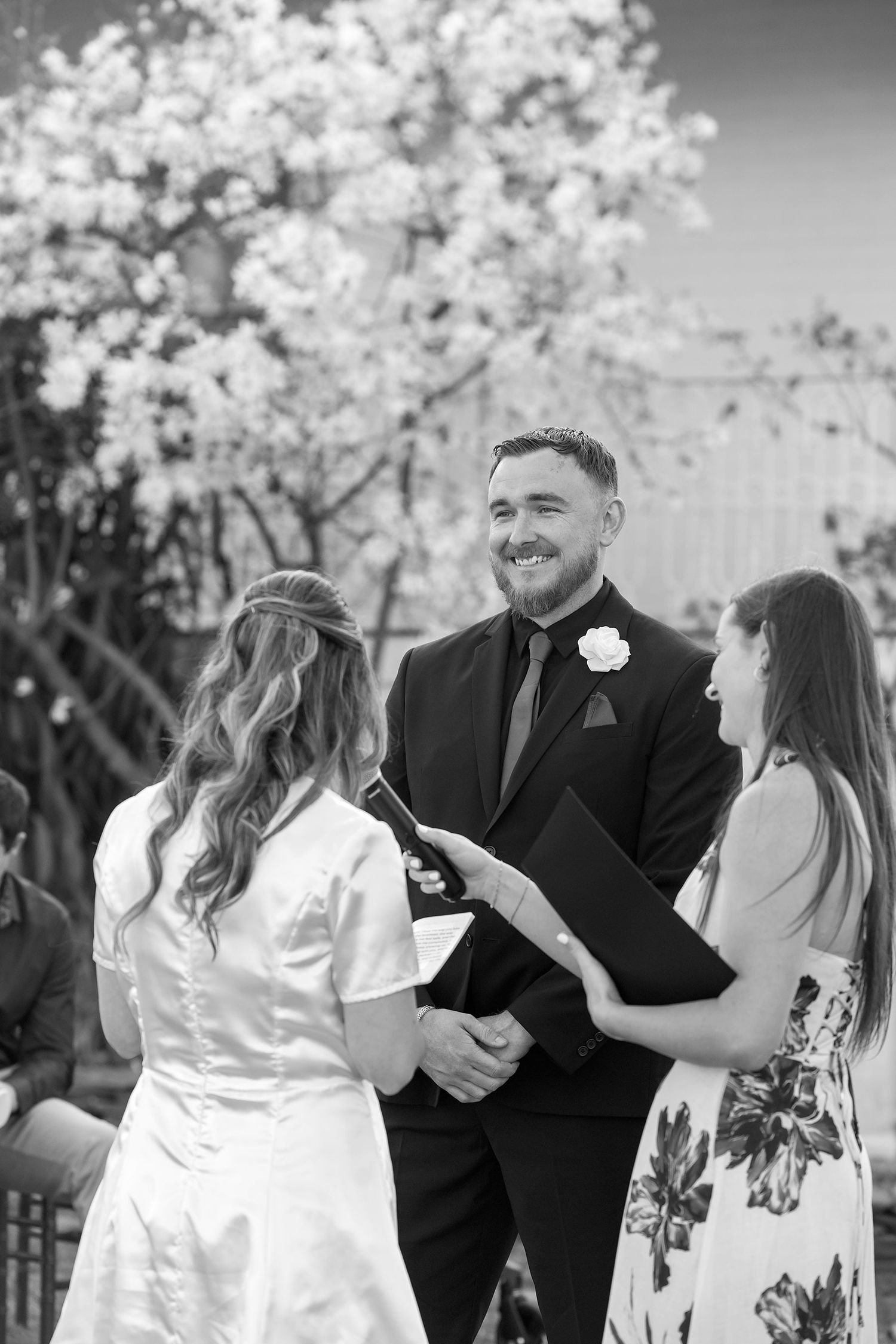A black and white image of a  Bride and Groom sharing a moment together during their vows in their outdoor wedding ceremony at Kimo Estate.