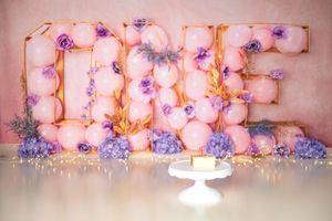 Pink and purple floral light decorations create a romantic ambiance on a wall with soft illumination.