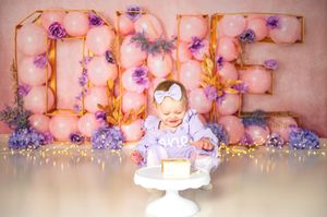 Elegant floral backdrop in pink and purple hues with delicate blooms creates a romantic atmosphere for a celebration.