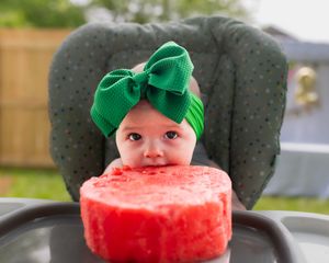 A kid takes bites out of a watermelon slice while wearing Mickey Mouse ears in this playful progression photo series.
