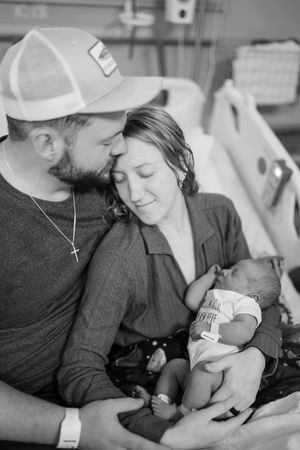 Black and white photos showing a tender bonding moment at a hospital bedside.
