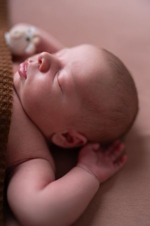 Seven peaceful profile views of a sleeping newborn baby arranged in a horizontal sequence.