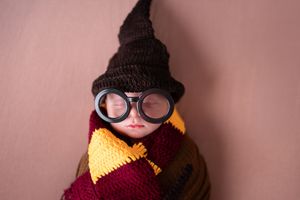 A series of whimsical newborn portraits featuring Harry Potter themed accessories and props.
