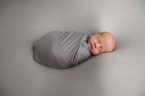 A gray curved memory support pillow shown from different angles on a white background.