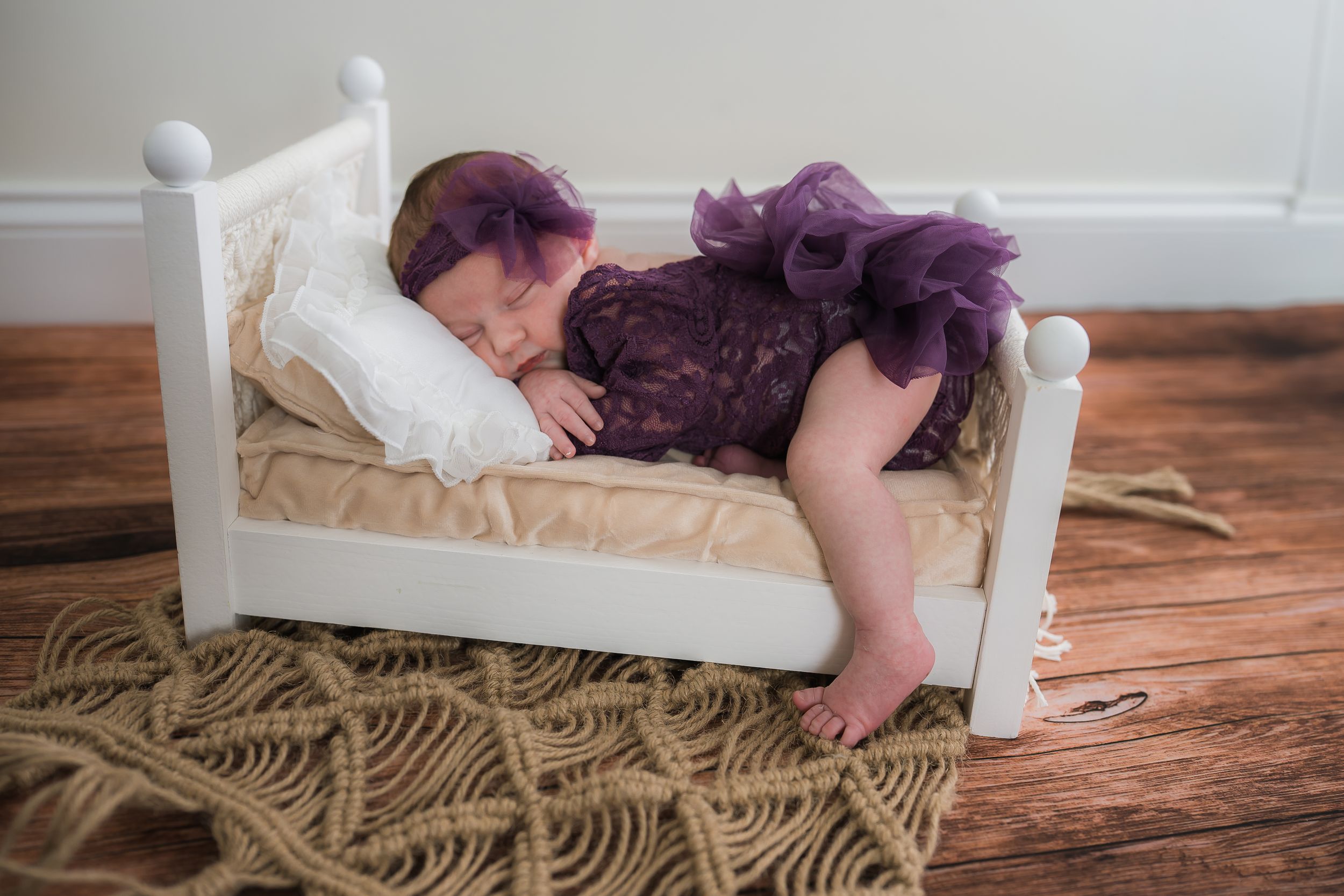 Child lying on white mattress creating imprints and shapes in memory foam material on wooden floor.