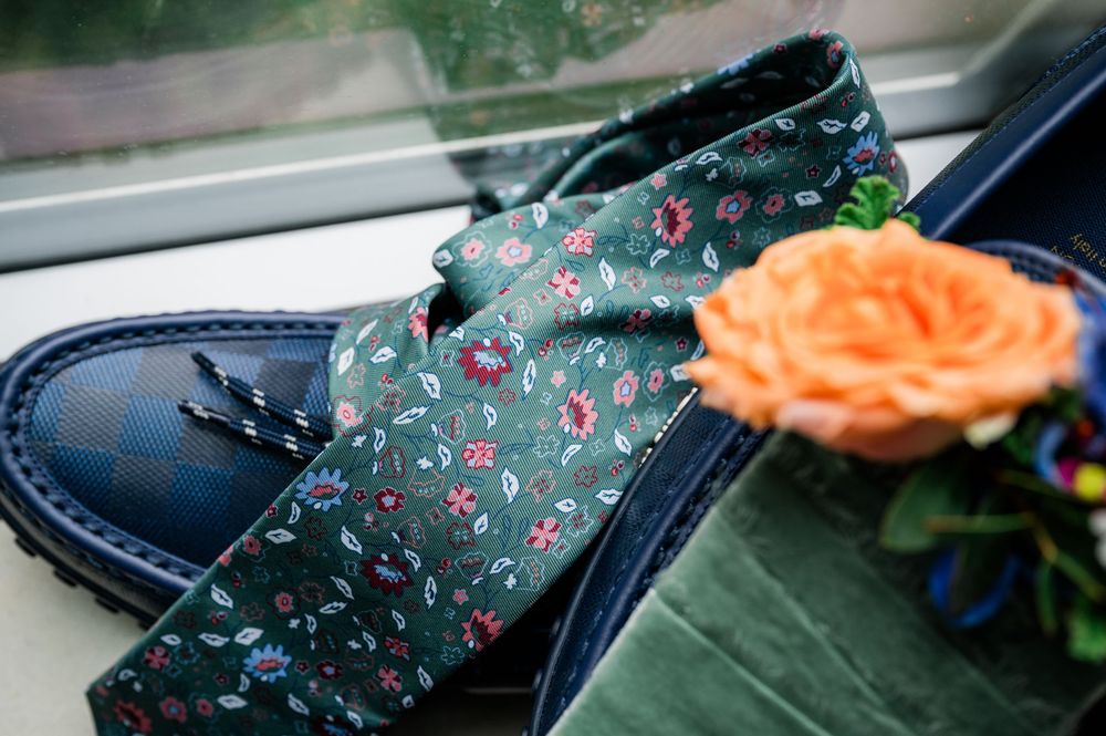 Close-up detail of a dark floral patterned fabric with an orange rose accent.