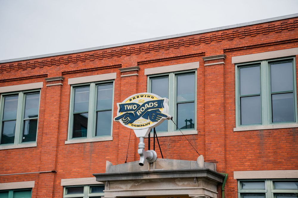 Vintage-style metal weather vane mounted on top of a red brick building.