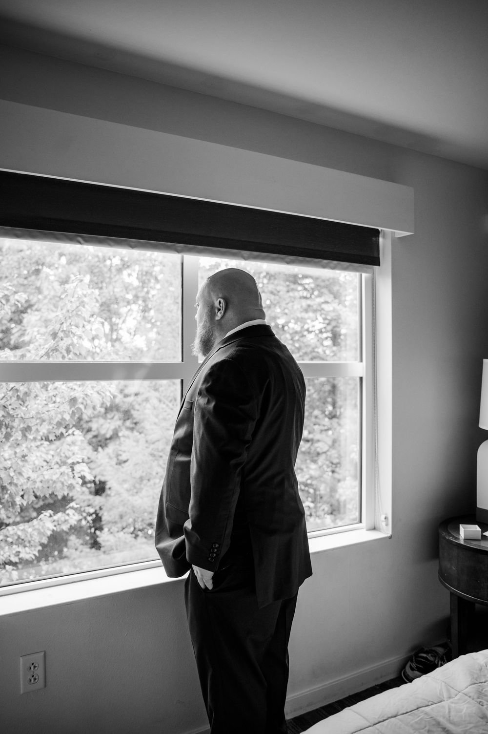 Black and white photograph showing silhouette looking through modern windows.