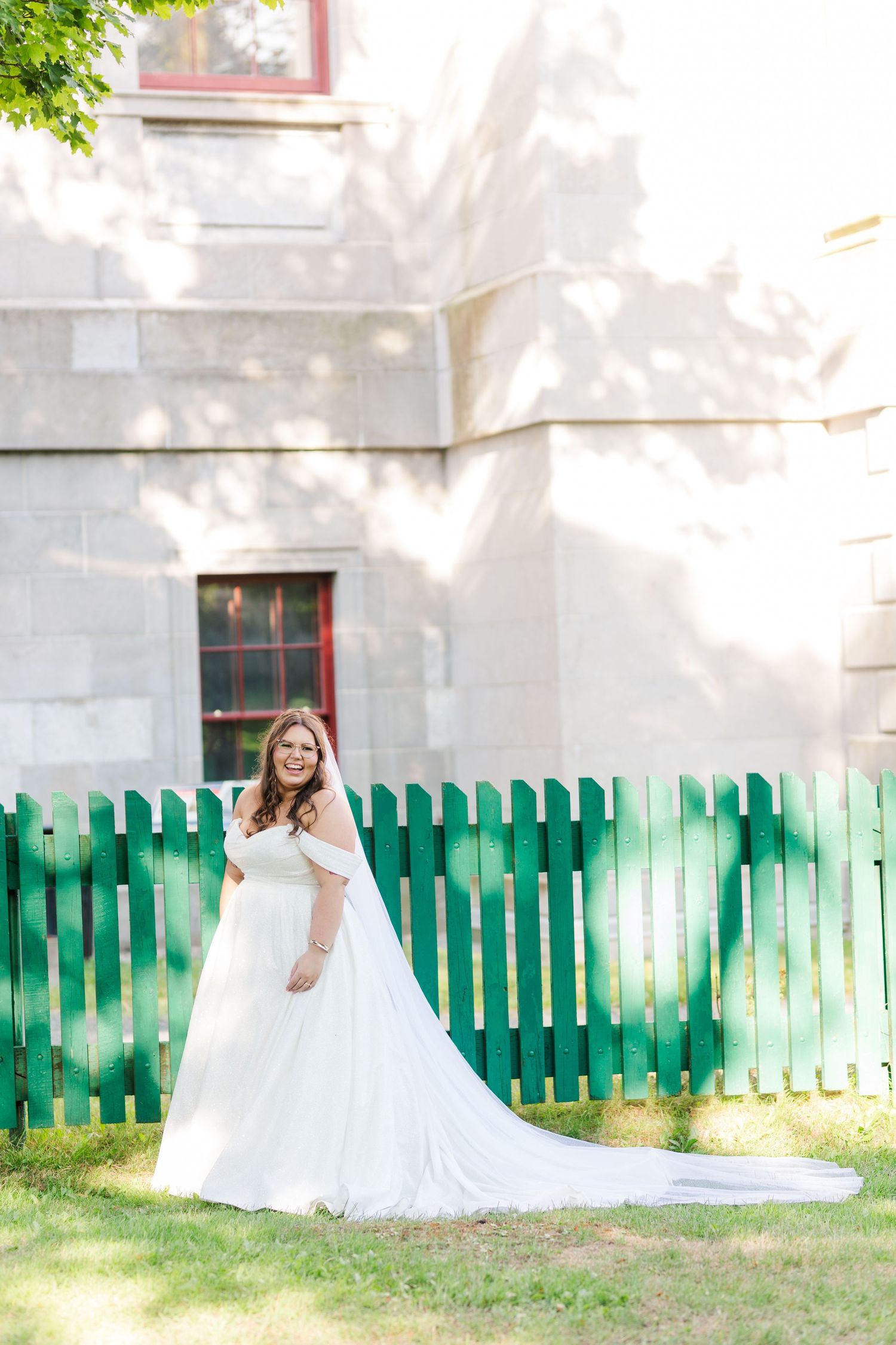A wedding gown sequentially moves across a green fenced lawn in a series of cascading romantic outdoor shots.