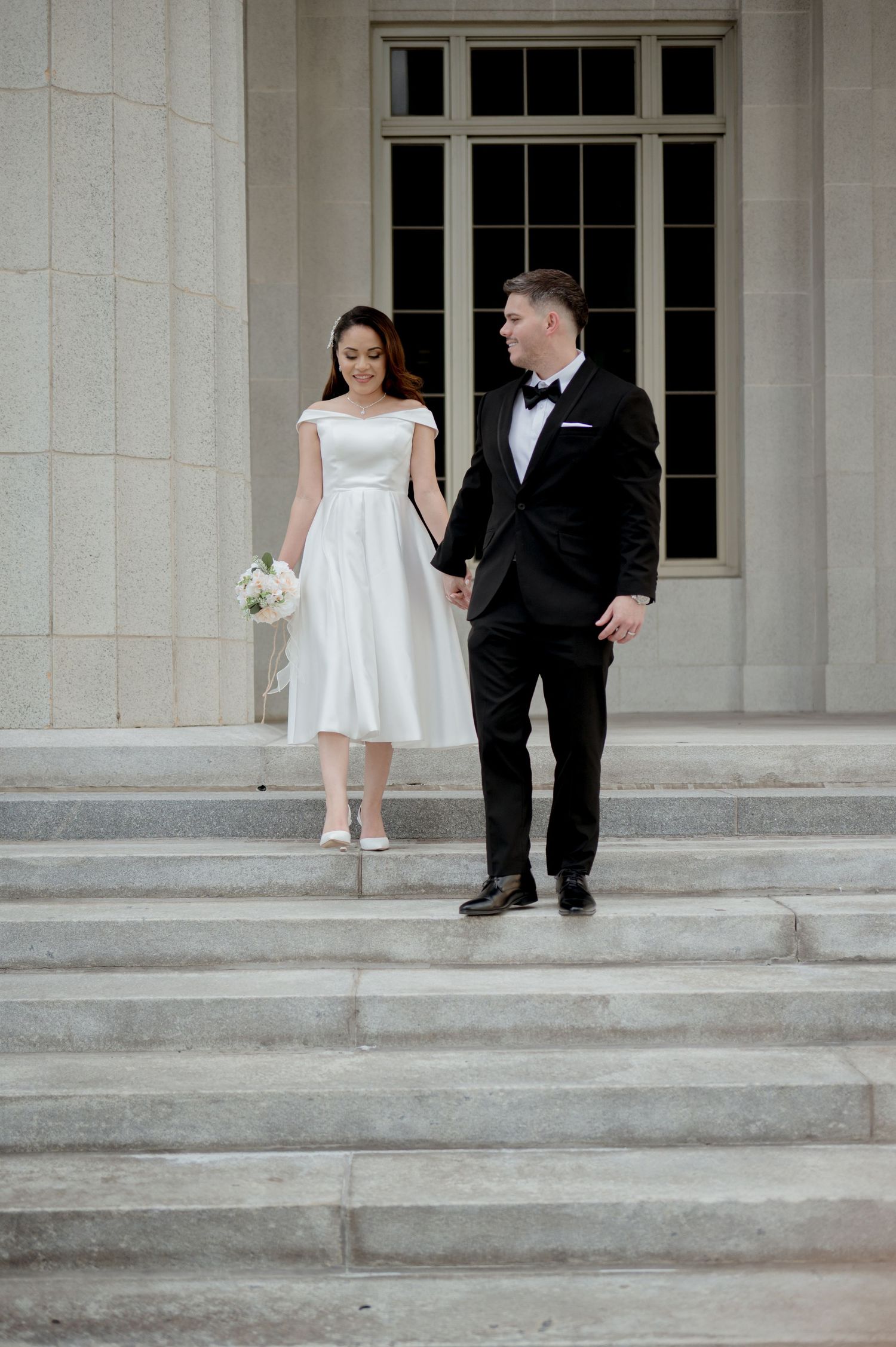 A sequence of minimalist wedding photos showing a bride and groom stepping down elegant stone stairs.