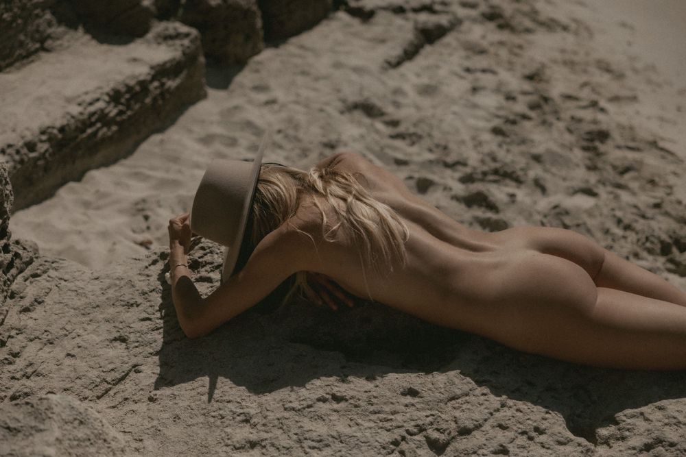 Artistic poses captured on sandy beach terrain in natural light.
