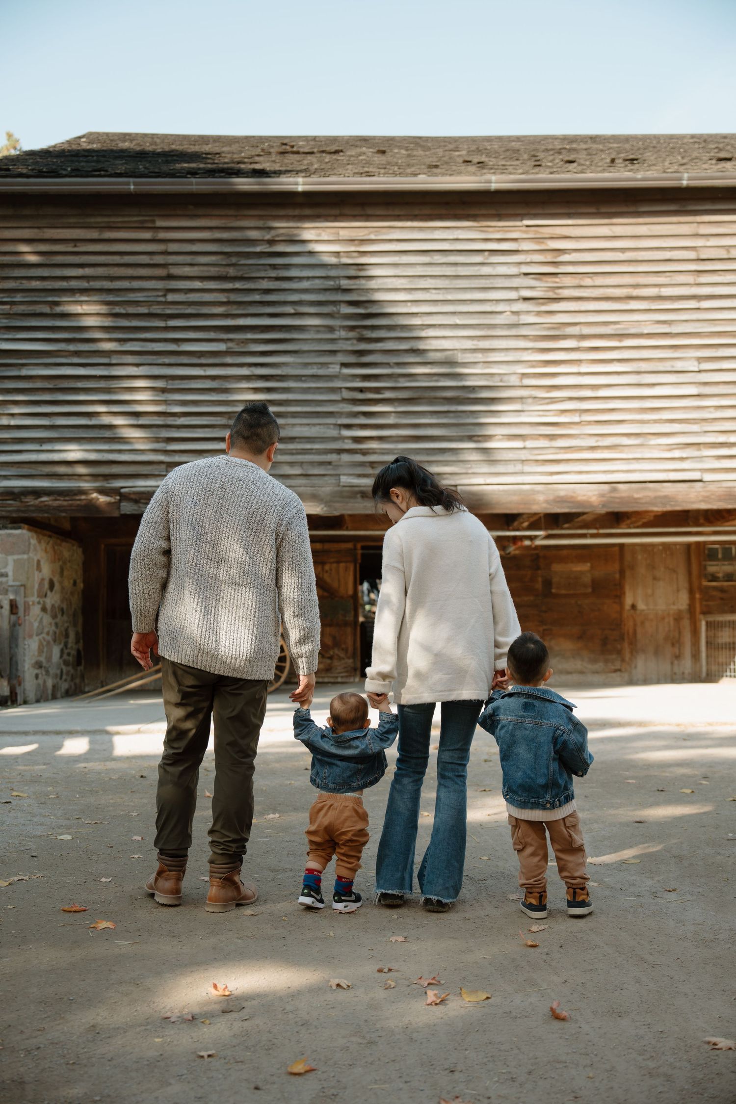 A series of images showing a family viewing something through horizontal gaps or slats in a wooden structure.