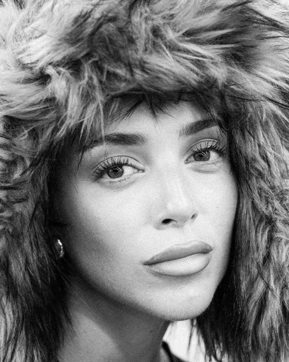 A black and white portrait photograph showing an artistic closeup view with dramatic lighting and styling.