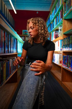 Casual library portraits with blue-tinted lighting and curved architectural features.