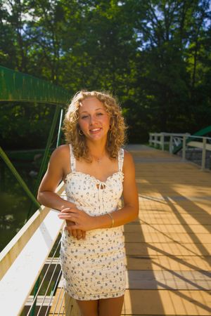 Summer portrait session on wooden deck featuring floral tank top in golden sunlight.