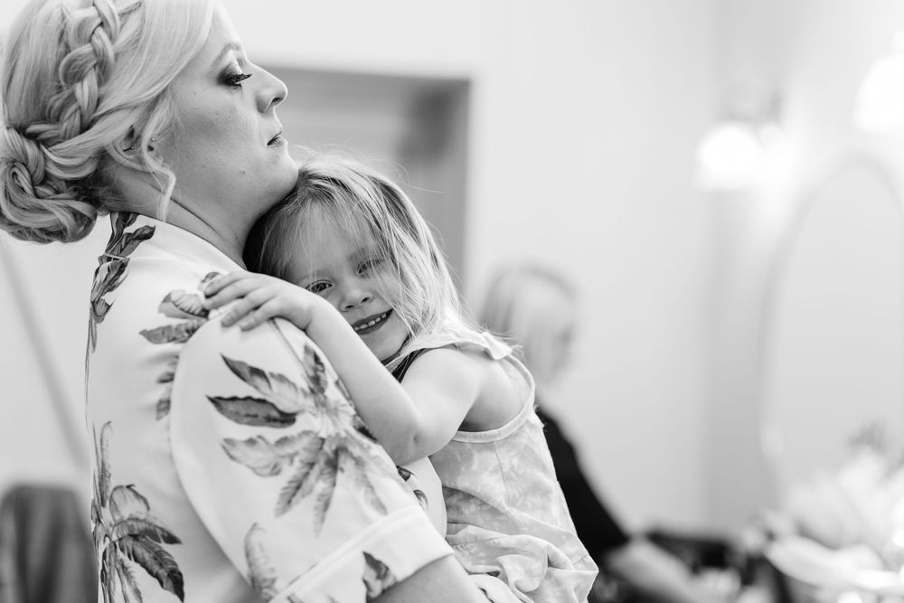 A tender black and white moment shared between two people hugging in an intimate setting.