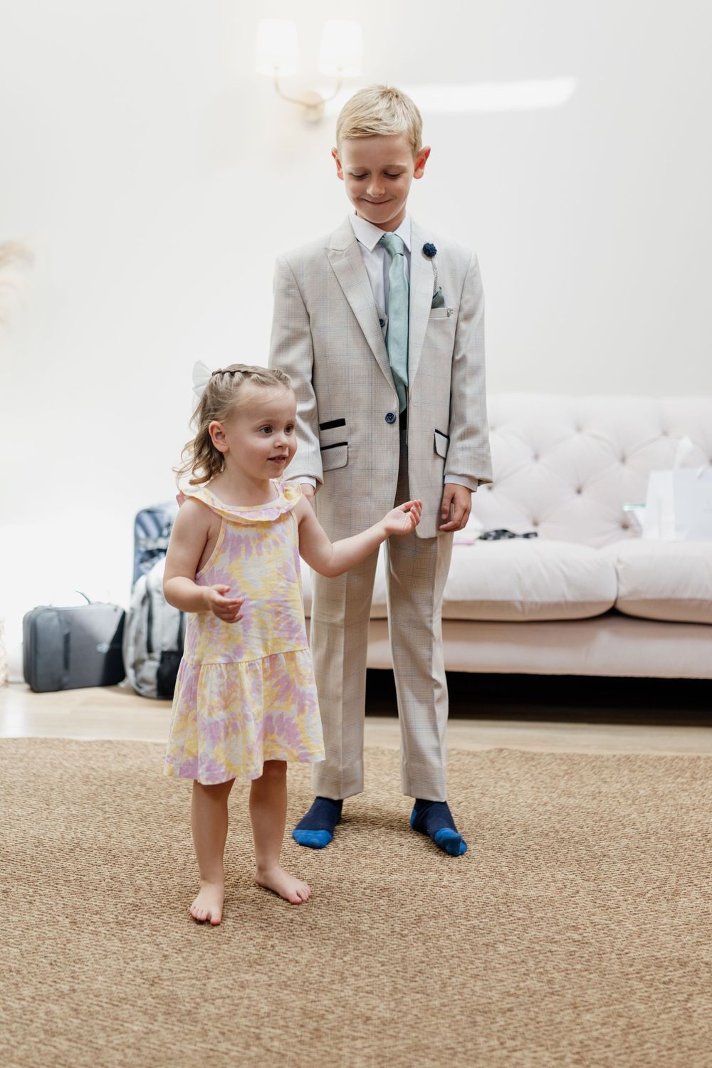 Young children in formal attire dancing together at a wedding reception.