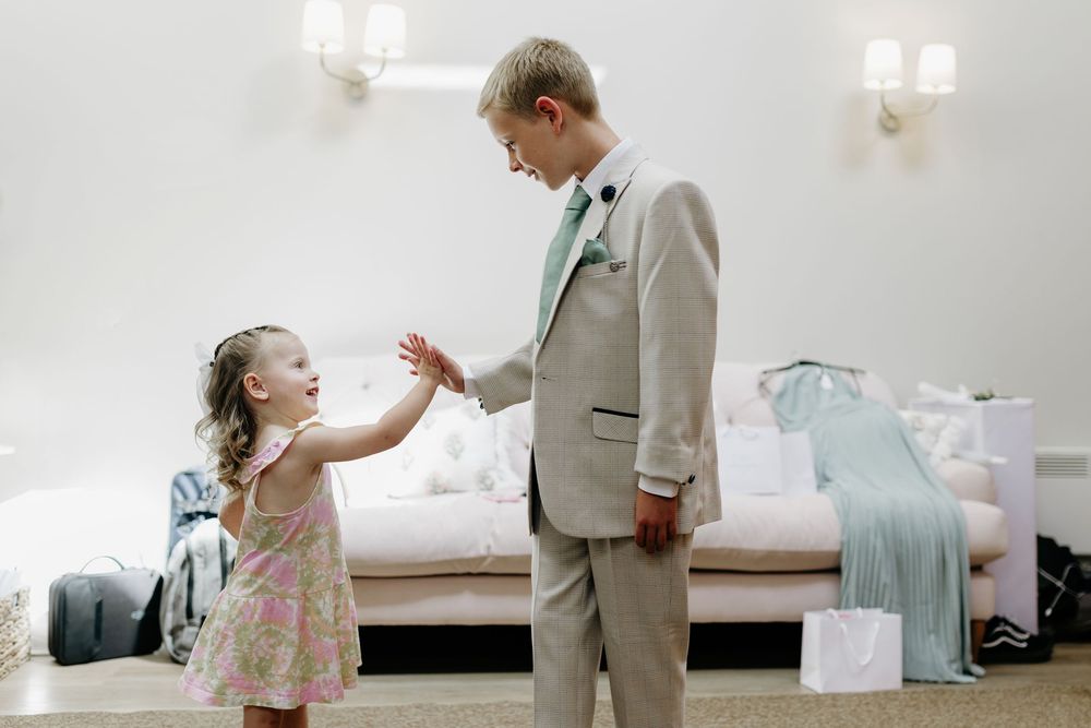 A little girl in floral dress shares tender moments with adults during a wedding celebration.