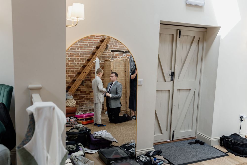 Empty reception venue with white walls and exposed brick showing setup before an event.