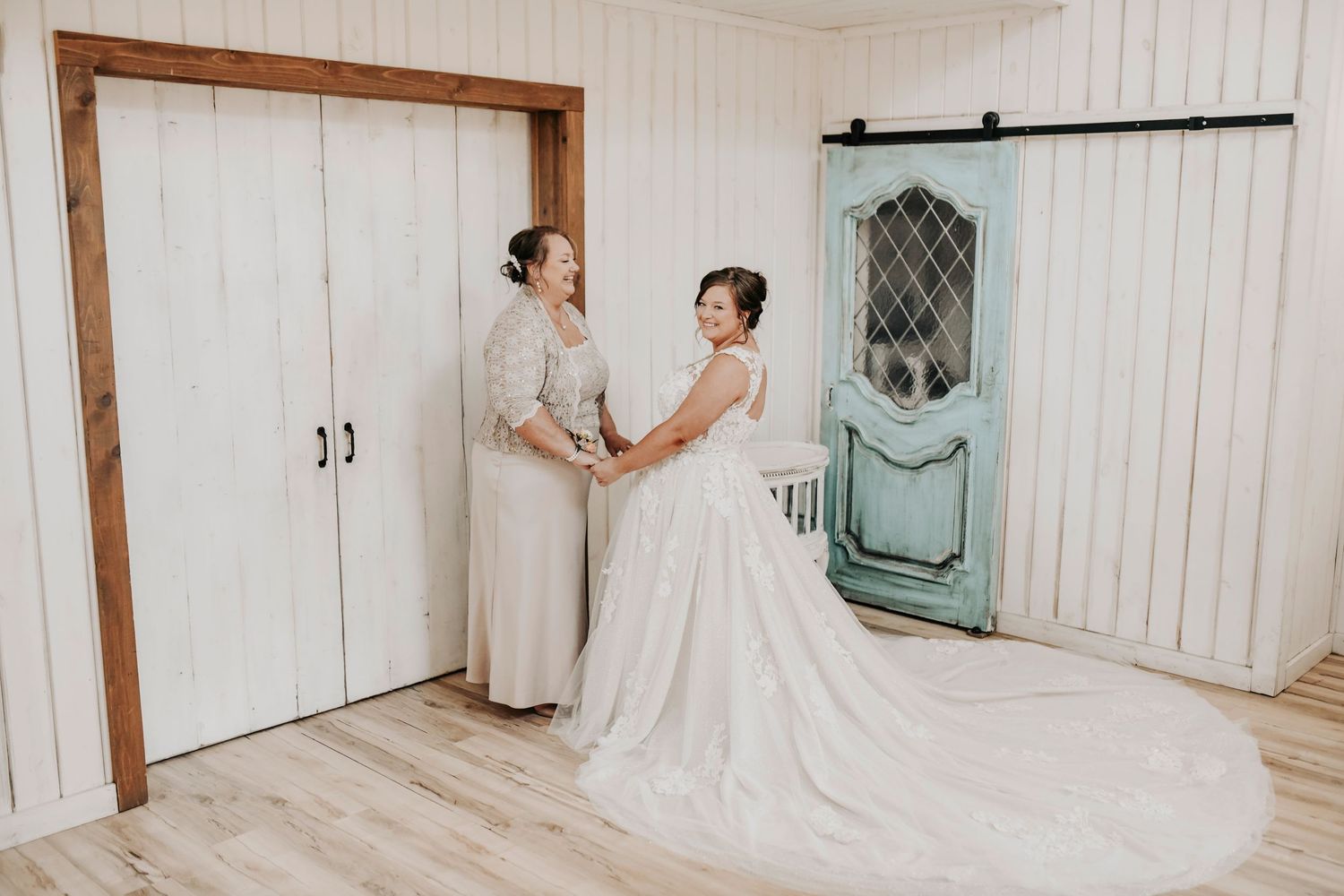 Bride being dressed by her mother in Shiplap Bridal Suite at Whispering Oaks