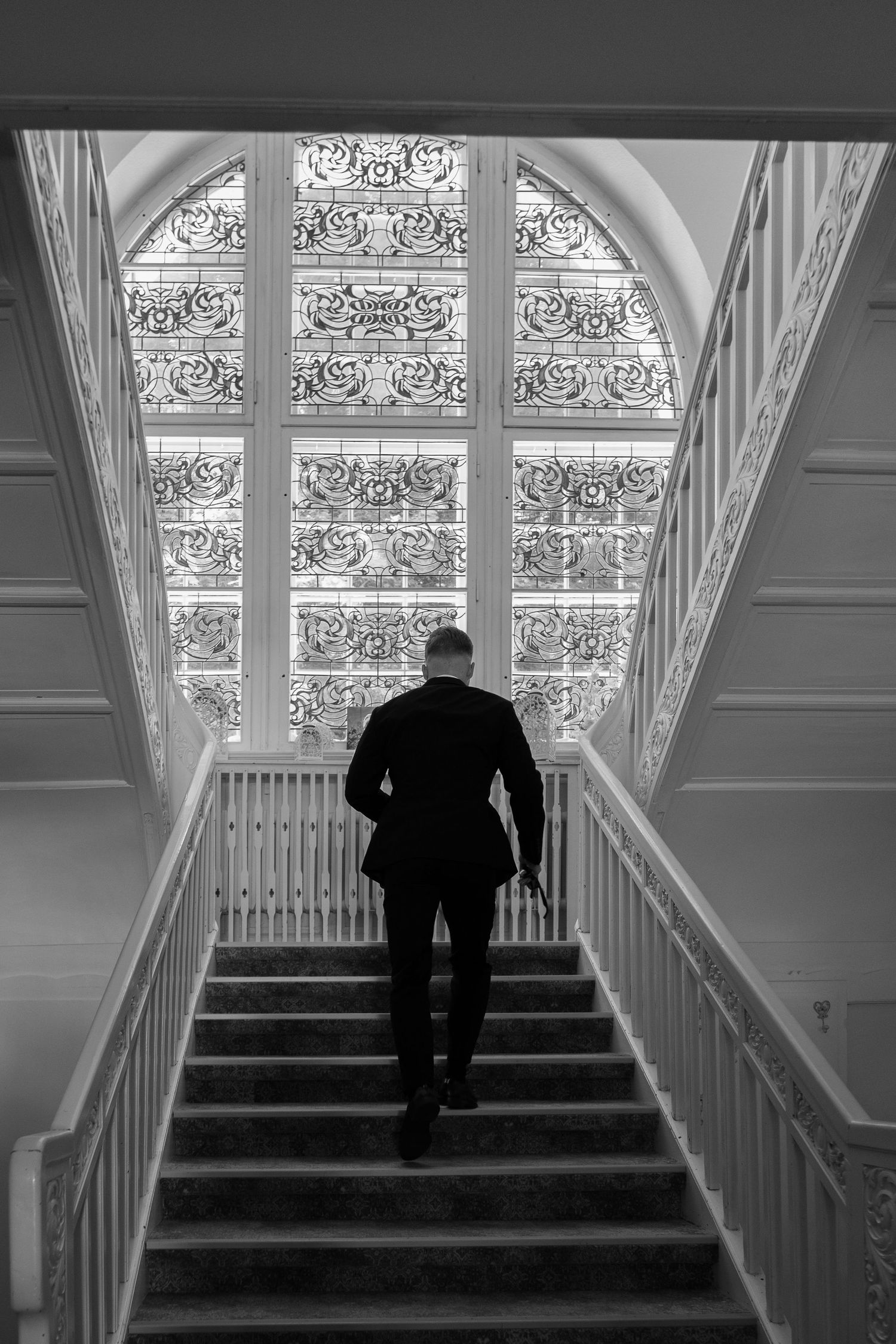 Standesamtliche Hochzeit im Schloss Wulkow, Bräutigam auf der Treppe im historischen Innenraum