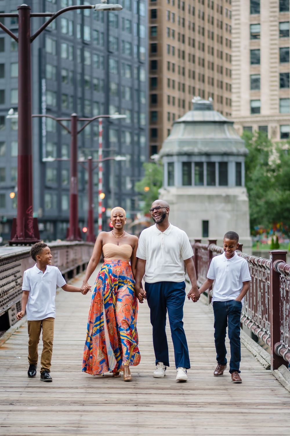 A couple walks hand in hand across a bridge in an urban setting, captured in a series of progressive shots.