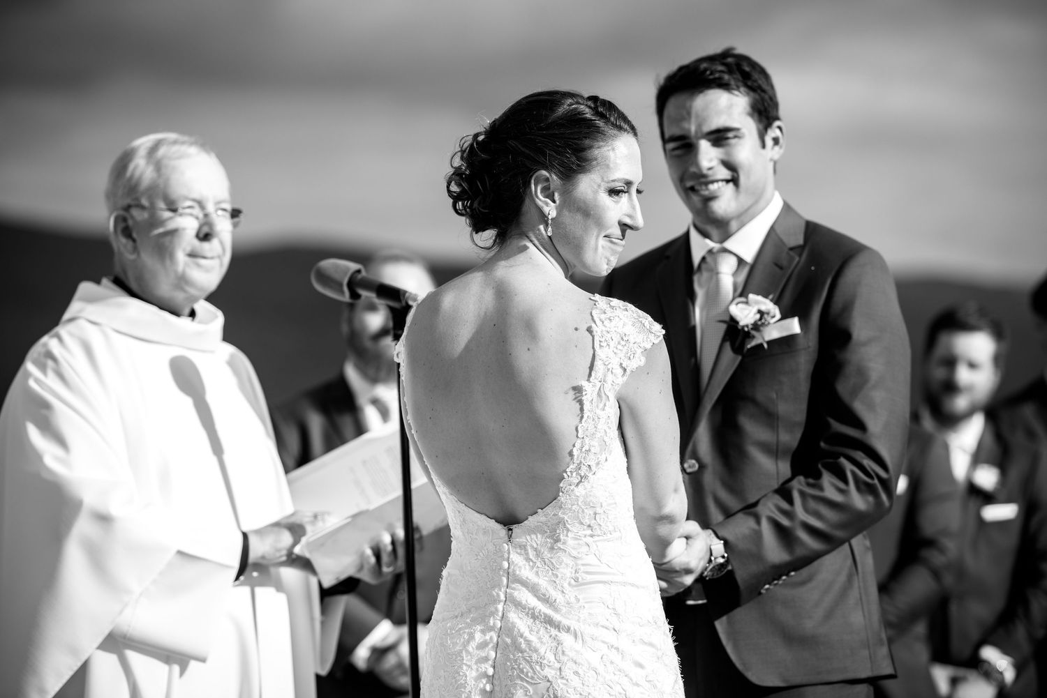 Wedding couple shares joyful laughter during outdoor portrait session in natural setting.