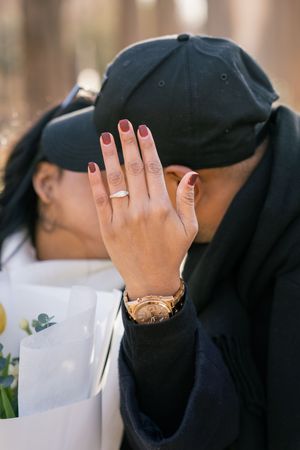 A hand with painted nails covers a face in an emotional moment.