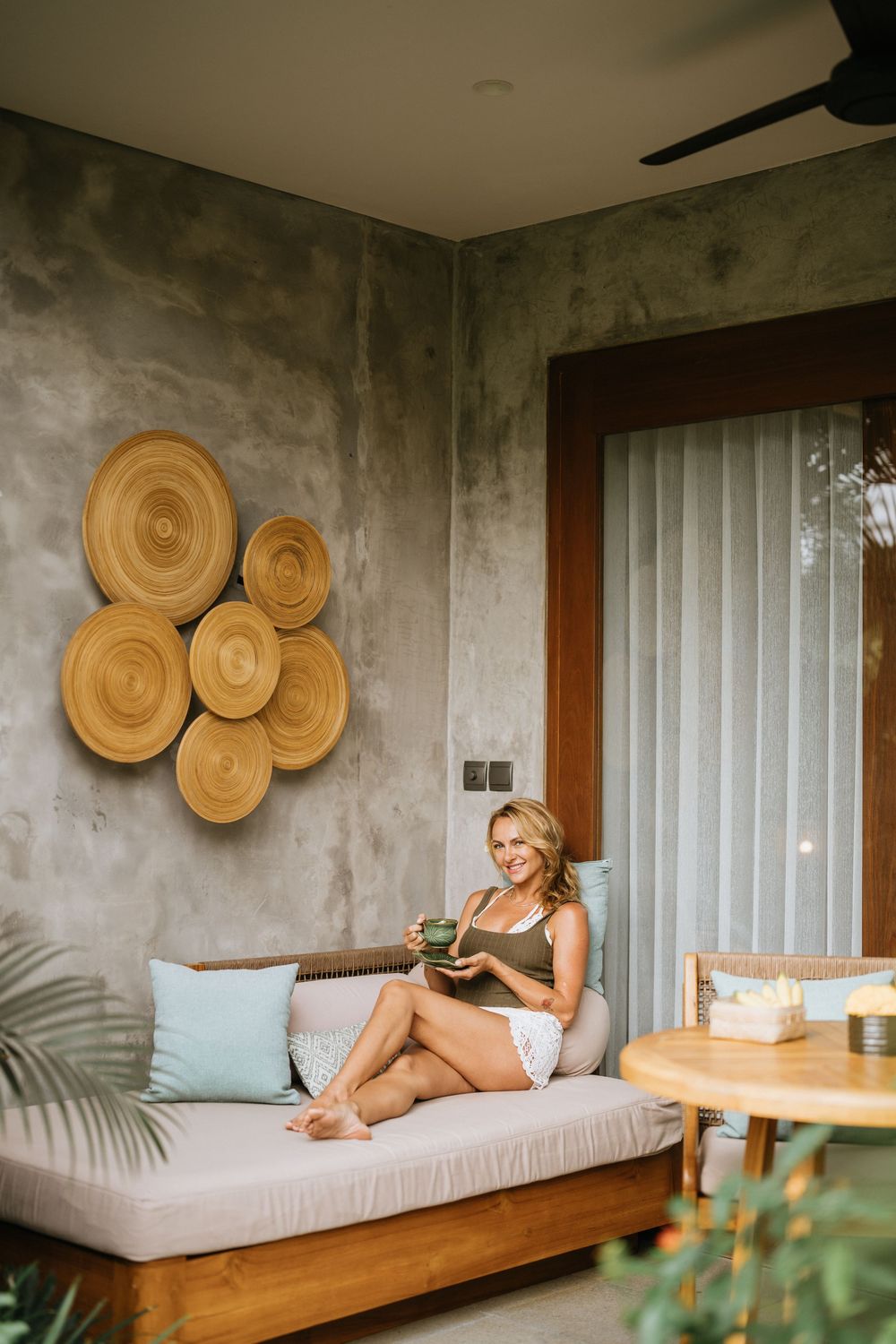 Modern tropical villa interior with wooden bench seating and decorative wall circles.