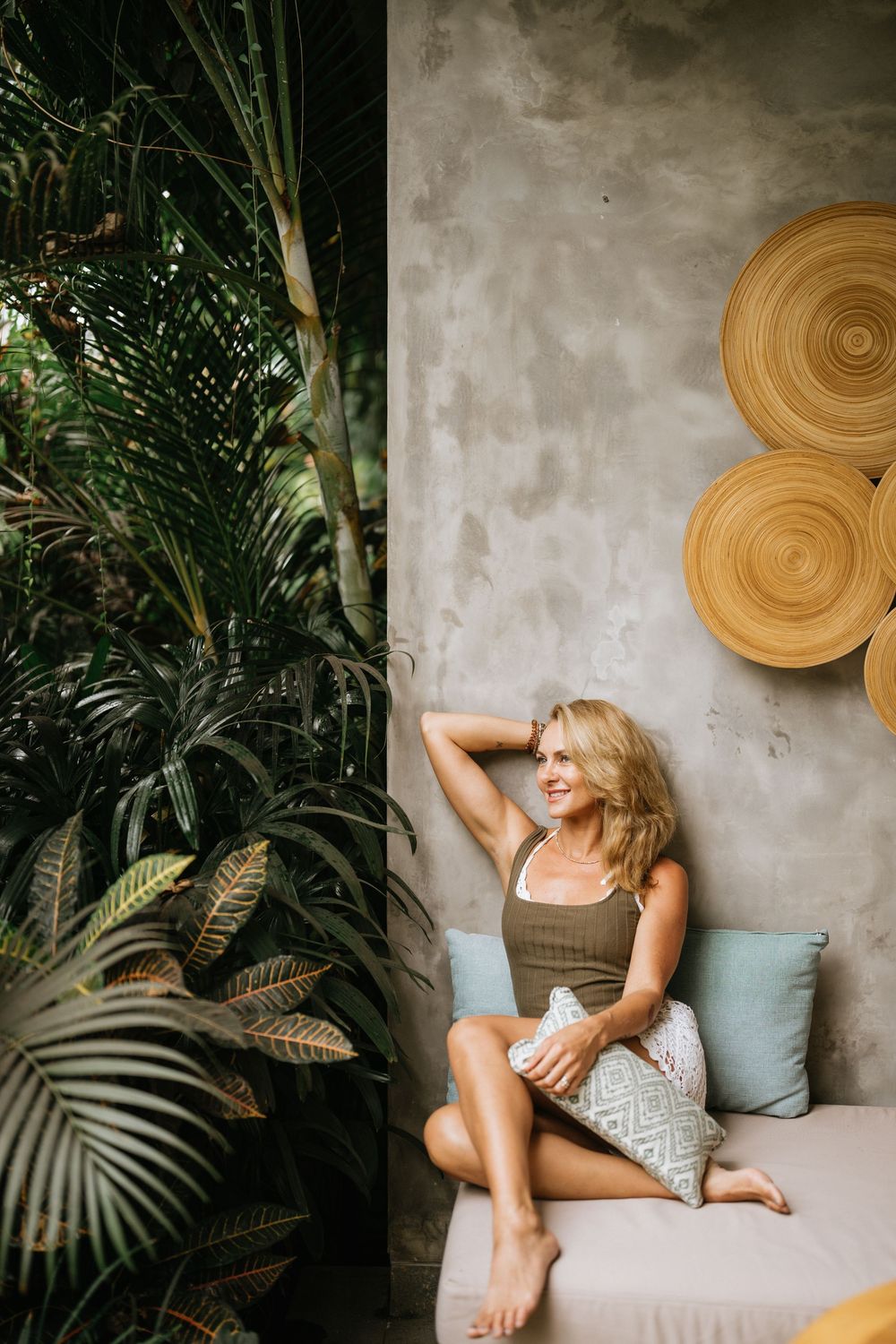 Bohemian styled interior with circular wall decor and tropical plants.
