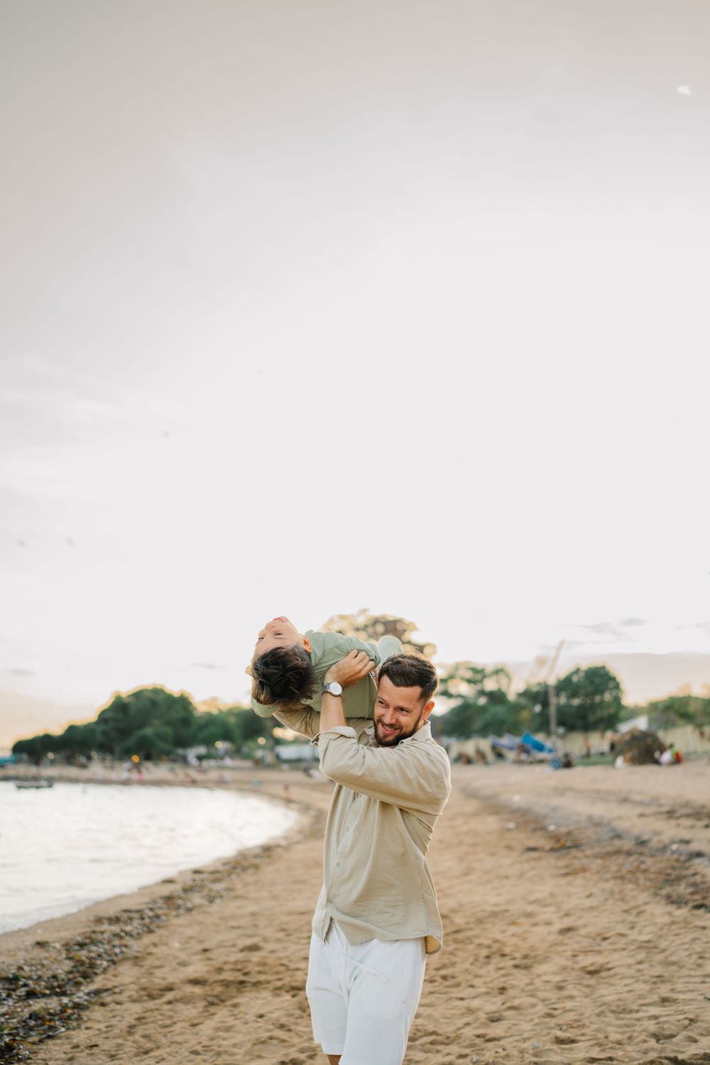 A playful moment captured on a beach at sunset.